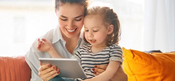 Mother and daughter sat on sofa looking at Prepay Power app